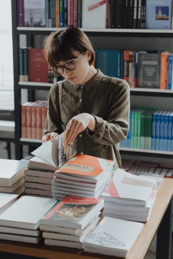 Someone checking out different genre of books